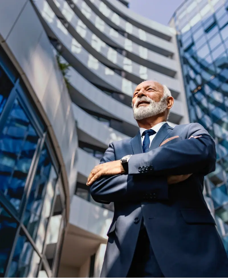 Free Guide 4 Man standing with arms crossed outside of tall corporate building.